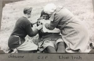 Photo of girl having a sling put on by two helpers